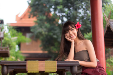 Naklejka premium Young Thai girl put ancient Thai dress sitting and smiling, central region of Thailand, Ayutthaya