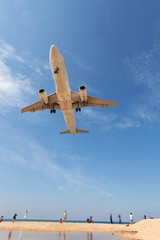 Fototapeta na wymiar Commercial airplane landing above sea and clear blue sky over beautiful scenery nature background,concept business travel and transportation background.