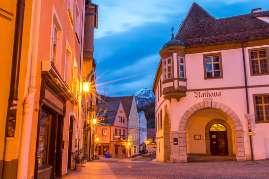 Beleuchtetes Rathaus in der Altstadt von Füssen am frühen Morgen