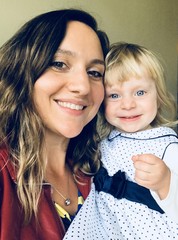 Selfie, young mother kissing her 2 years old toddler Blonde beautiful daughter