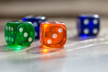 Colourful green, orange and blue gambling dice on table