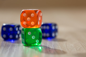 Colourful green, orange and blue gambling dice on table