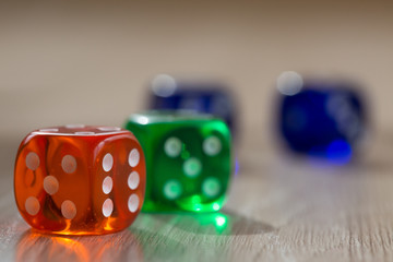 Colourful green, orange and blue gambling dice on table