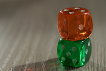 Colourful green and orange gambling dice on table