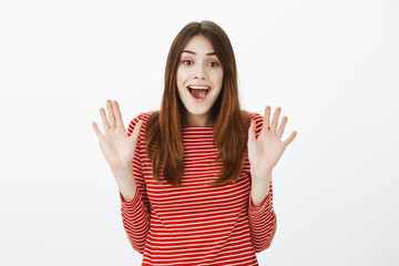 Okay, you won, I give up. Portrait of happy charming caucasian woman with brown hair, raising palms...