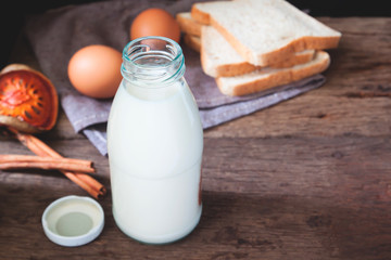 Milk bottle with sliced breads and egg on wooden table, Healthy lifestyle, Dairy product