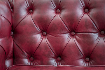 Fototapeta premium Closeup texture of vintage red leather sofa for background