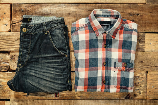 Checkered Shirt And Jeans On The Wooden Floor. Top View. Flat Lay.