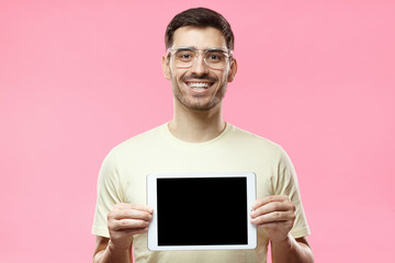 Studio picture of positive man isolated on pink background standing in casual clothes holding...