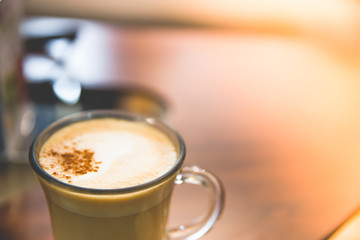 Close up Glass of hot Cappuccino coffee on wood table.