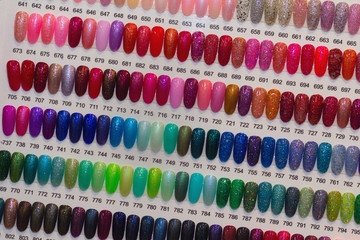 Colorful artificial nails on shelves in beauty shop