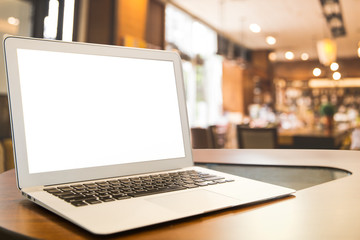 Fototapeta premium Mockup image of laptop with blank white desktop screen on wooden table in modern cafe.