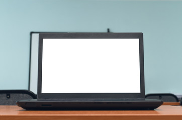 Laptop computer with blank white screen on the school desk table in classroom. Education concept background.