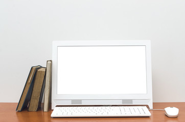 Fototapeta premium Desktop computer with blank white screen and books on the school desk table isolated on white background. Education concept background.
