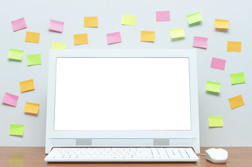 Desktop computer with blank white screen and colorful stickers on the school desk table isolated on white blackboard background. Education concept background.