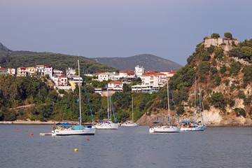 Yachts sail near a fortress on a hill Parga Greece