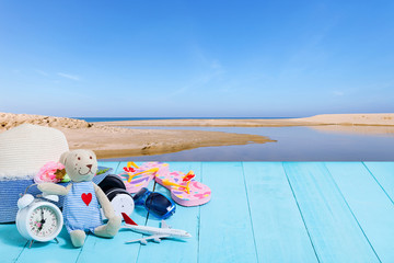 Teddy bear with white alarm clock,Beach accessory,hat,sunglasses,shoes on blue wooden plank background, concept summer holiday background and summer sale