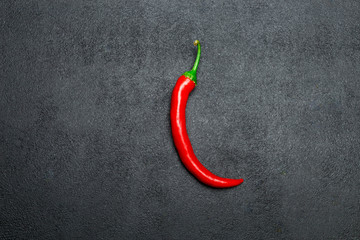 red chili pepper on dark concrete background