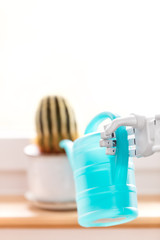 Roboterarm oder moderne Prothese mit Gießkanne