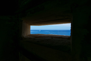 Looking through a small window, which looks over the sea