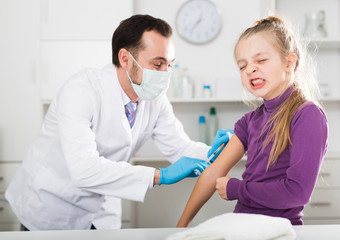 Obraz premium Male doctor injecting little patient