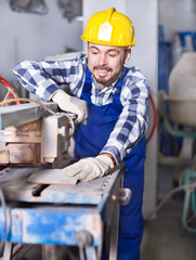 Working man practicing with disk saw machine