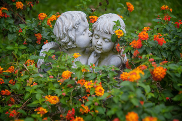 ANGELS IN LOVE. Sculptures of boy and girl angels surrounded with flowers hugging and cuddling. The...