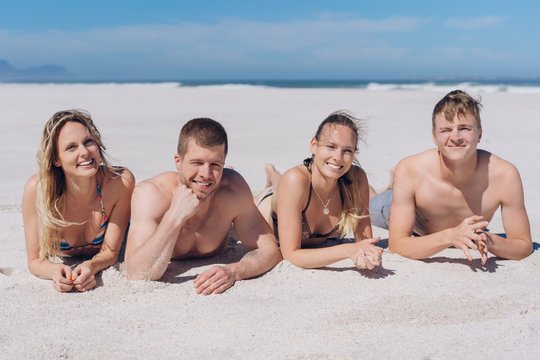 Two attractive young couples relaxing on a beach