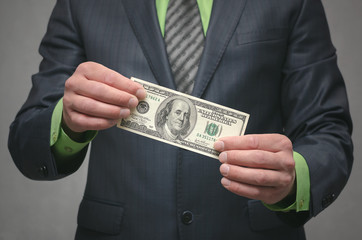 Pay the debt. Not enough money. Payment by invoices. Low salary concept. Poverty background. Businessman holding in hands a money.