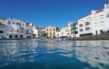 Buildings on the waterfront with a small beach in the seaside village of Cadaques, seen from water surface, Mediterranean sea, Costa Brava, Catalonia, Spain