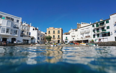 Seaside village of Cadaques, buildings on the waterfront with a small pebble beach seen from water surface, Mediterranean sea, Costa Brava, Catalonia, Spain