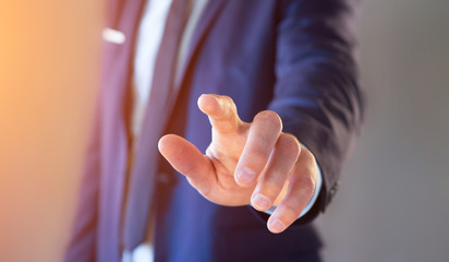 Naklejka premium Businessman touching with his finger an interface on a color background