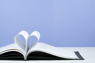 Old open hardback book, page decorate into a heart shape for love in Valentine's. love with open book heart.