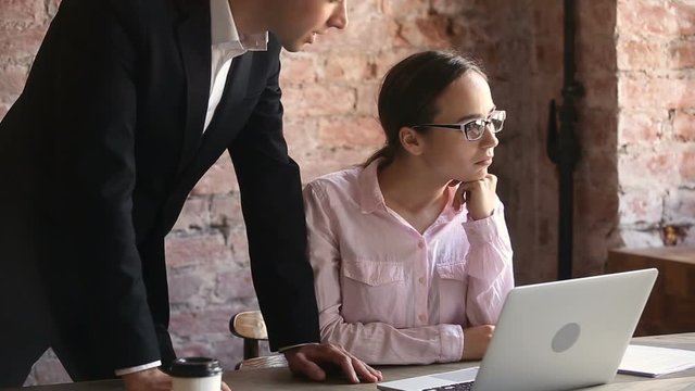 Angry boss scolding young employee for bad result at workplace, dissatisfied executive in suit pointing at laptop reprimanding incompetent intern for ineffective poor performance or mistakes in work