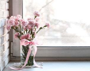 pink carnations on white windowsill