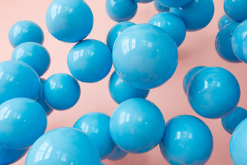 blue balloons, blue bubbles on pink background. Modern punchy pastel colors. Close up shot with shiny reflection
