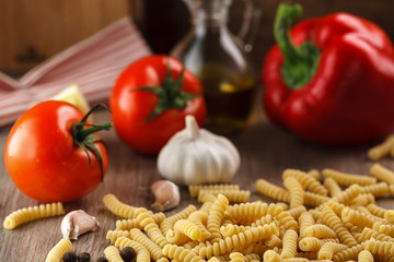Italian raw pasta fusilli on the background of other ingredients for cooking