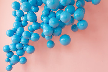 Bunch of blue balloons, blue bubbles on pink background flying up. Modern punchy pastel colors