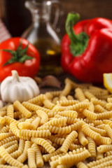 Italian raw pasta fusilli on the background of other ingredients for cooking