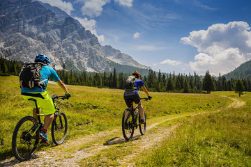 Mountain cycling couple with bikes on track, Cortina d'Ampezzo, Dolomites, Italy - 199767359
