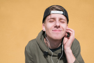 A student is listening to music on headphones on an orange background, and the gimmicks are...