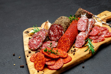 Dried organic salami sausage on wooden cutting board