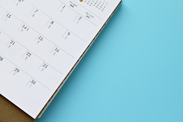 Travel planning, Business planing or meeting concept : Top view or flat lay of calendar page on blue background with copy space, ready for adding or mock up