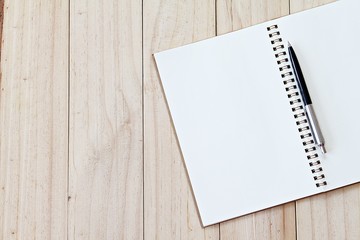 Still life, business, office supplies or education concept : Top view image of open notebook with blank pages and pen on wooden background with copy space, ready for adding or mock up