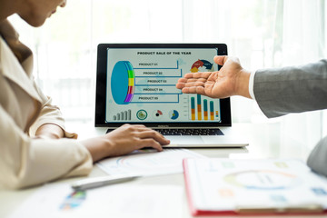 Obraz premium financial Image of two business people pointing at business document during discussion at meeting room , Notebook on wood table - Business concept
