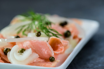 Pieces, slices of raw salmon in a marinade of pure lemon juice - halthy meal - closeup
