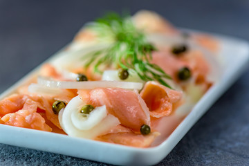 Pieces, slices of raw salmon in a marinade of pure lemon juice - halthy meal - closeup