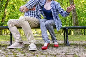 Man and woman sitting on the bench in the park.