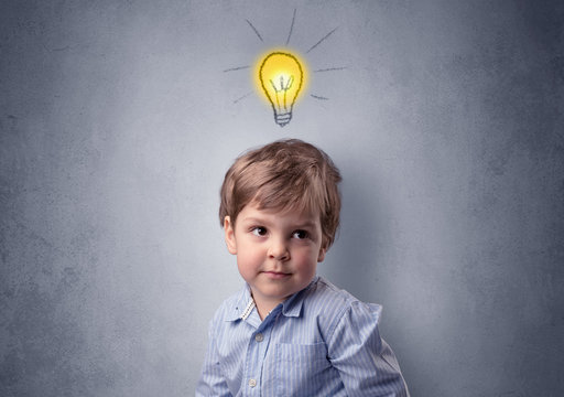 Adorable little kid mull over in front of a grey wall with idea symbol above his head