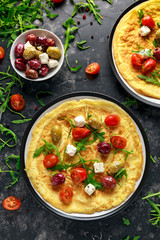 Vegetables Eggs Omelette with tomatoes, wild rocket, greek cheese, olives in a plate. Morning breakfast. healthy food